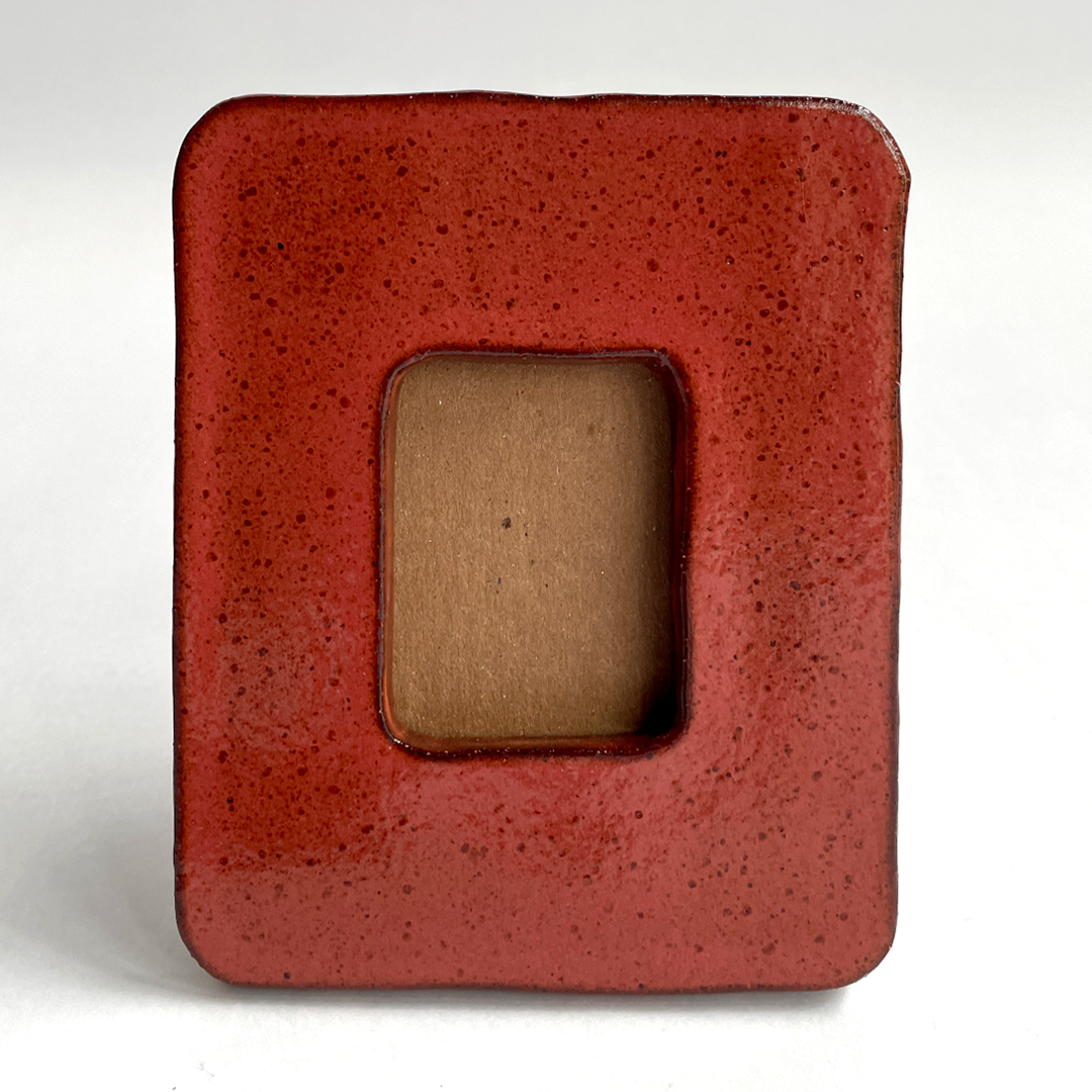 A square ceramic Instax picture frame with rounded corners, featuring a glossy terracotta red glaze. 